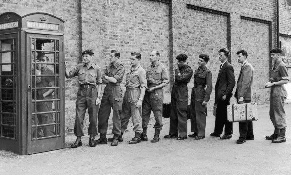 Group of people standing in a line to make a call