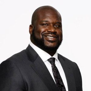 A black man in a suit and tie smiling for the camera.